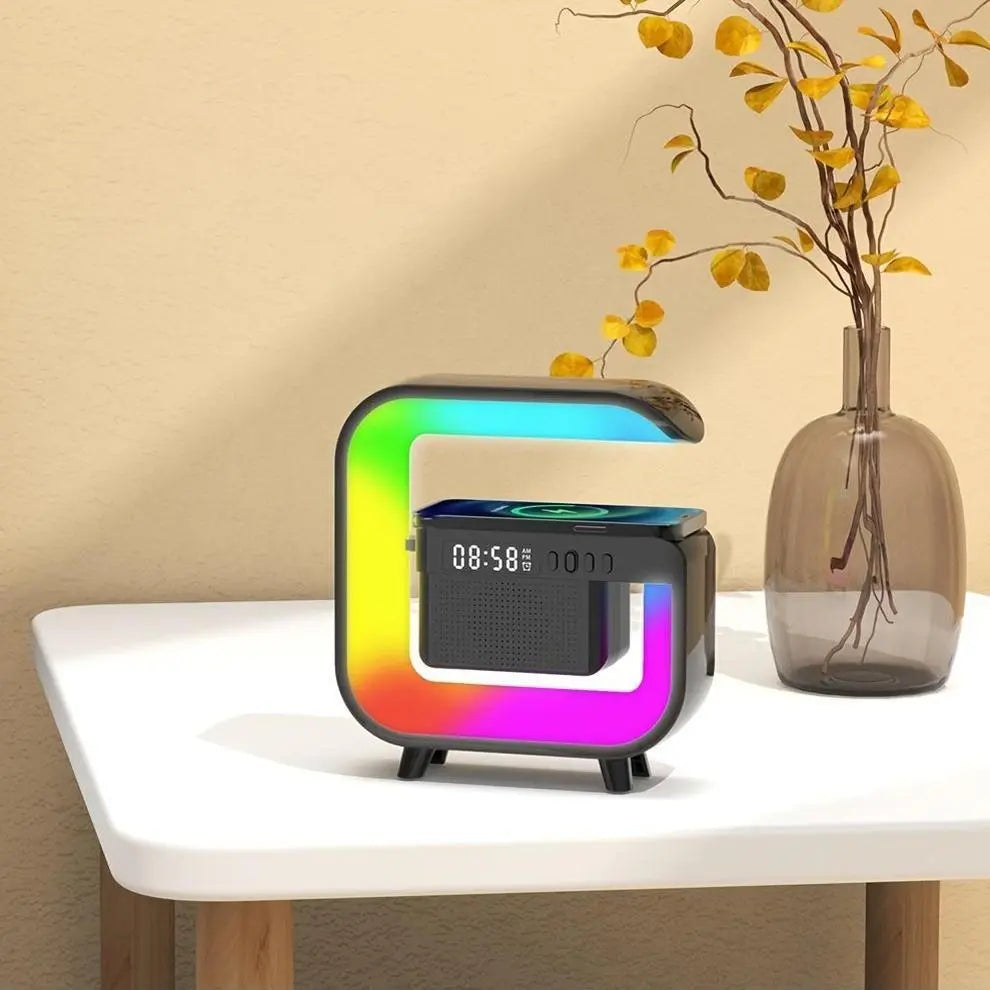 Colorful square clock on a white surface with a vase of yellow leaves in the background